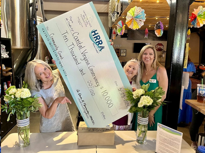 Mary Ann Sanders, CVC Board Chair, Helen Kuhns, Executive Director, and Jennifer Cool, Board Secretary, trying to put the big HRRA check in the donations box.